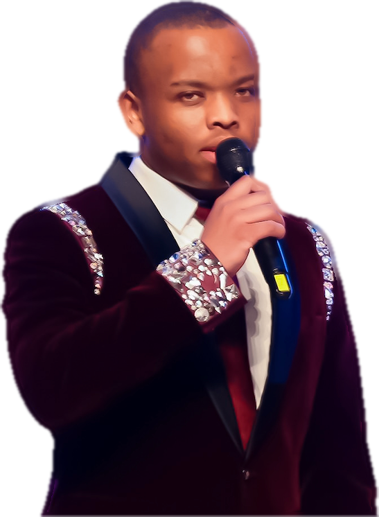 Lawrence Kamau on stage in a wine velvet jacket, speaking into a microphone